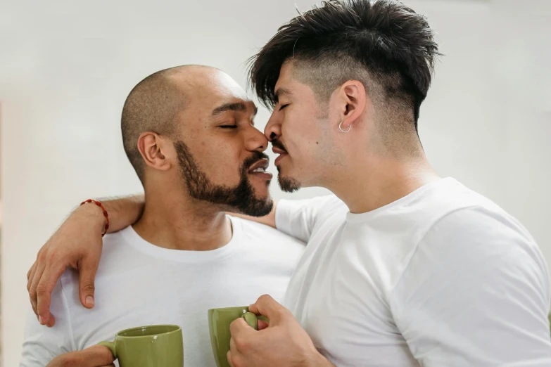 two males, one with beard, another with his arm around the other