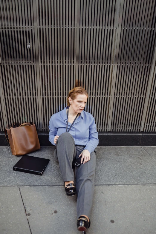 a woman sits on the street in front of some luggage