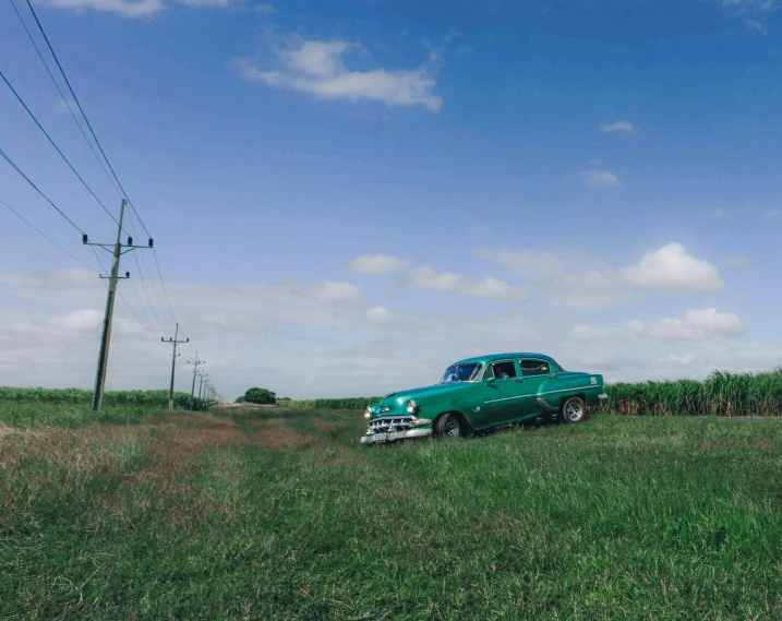 an antique green car parked on the side of the road