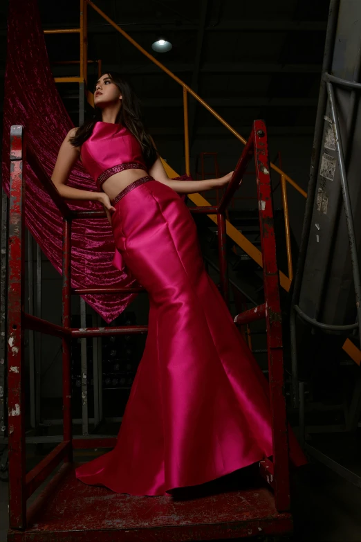 a woman standing in a red dress near stairs