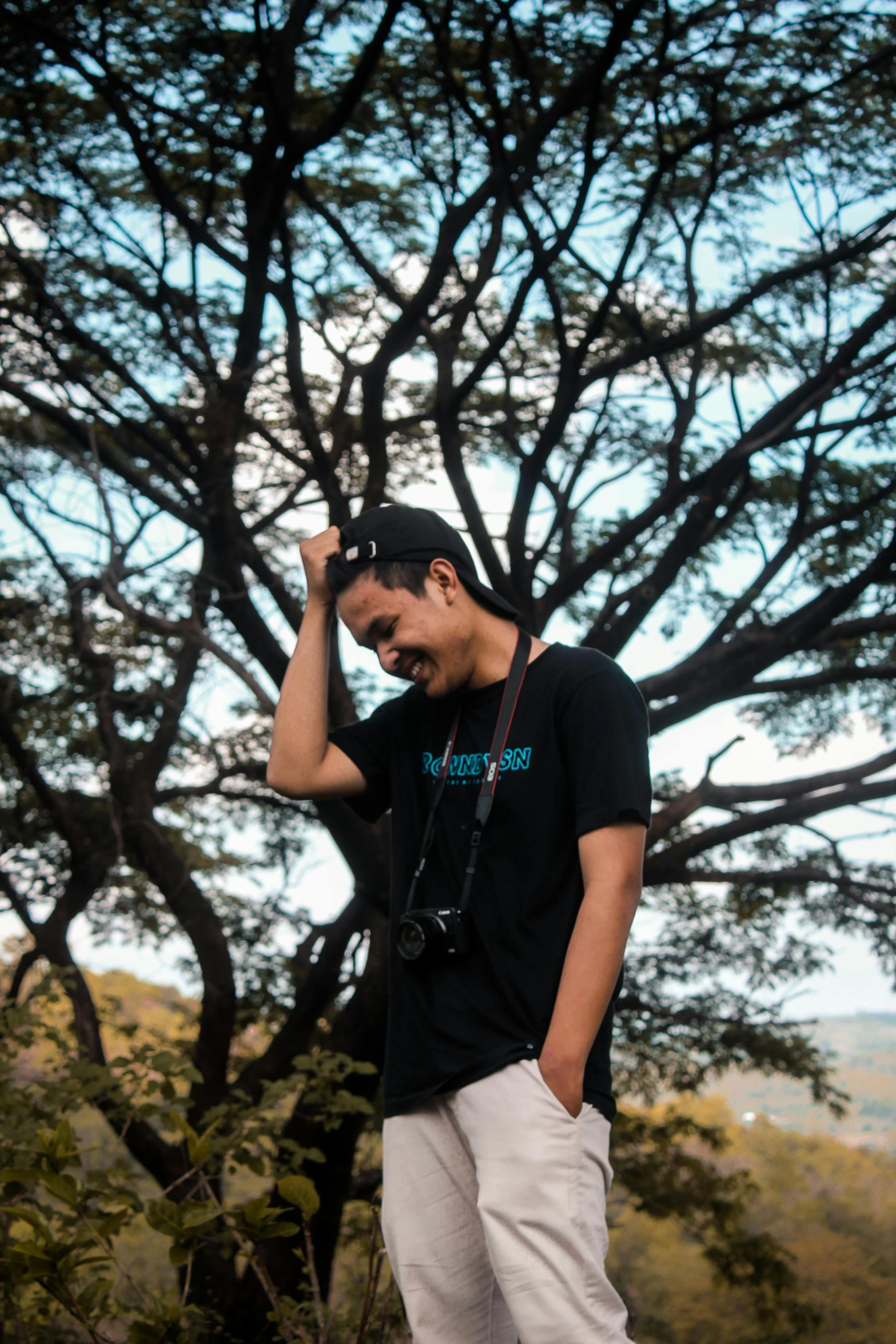 a man that is standing up near a tree