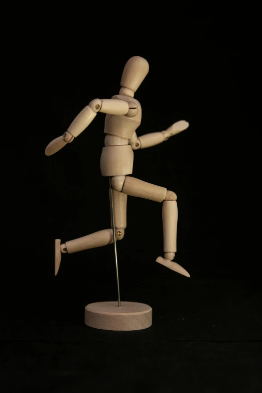 a wooden mannequin is posed on a table
