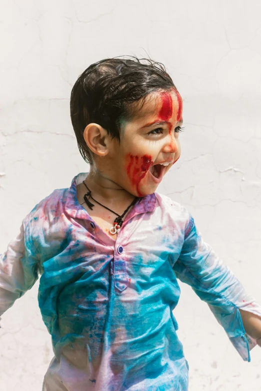 a small child with colored paint on his face