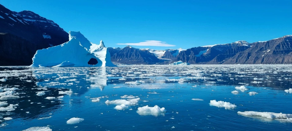 an iceberg in the ocean that has very many small white pieces