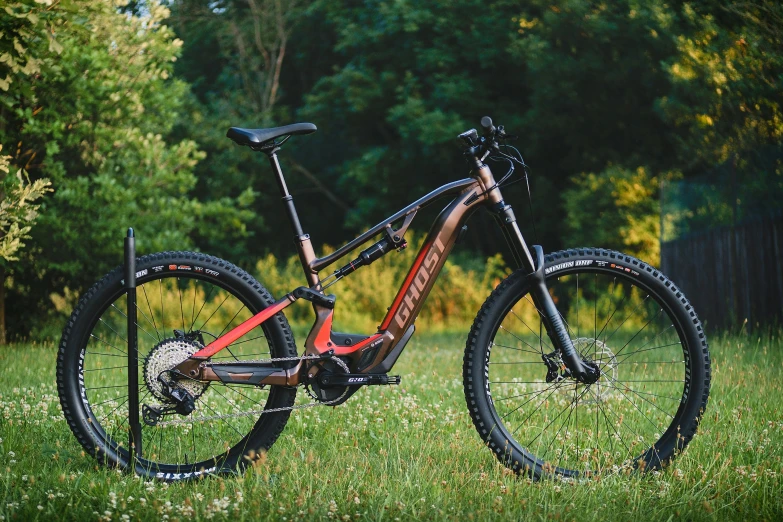 a mountain bike parked in a field on a wooded trail