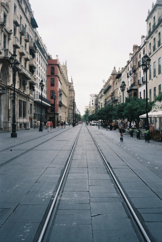 people stroll on an empty street in a city