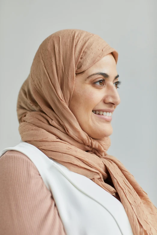 a woman in a pink hijab looking away from the camera