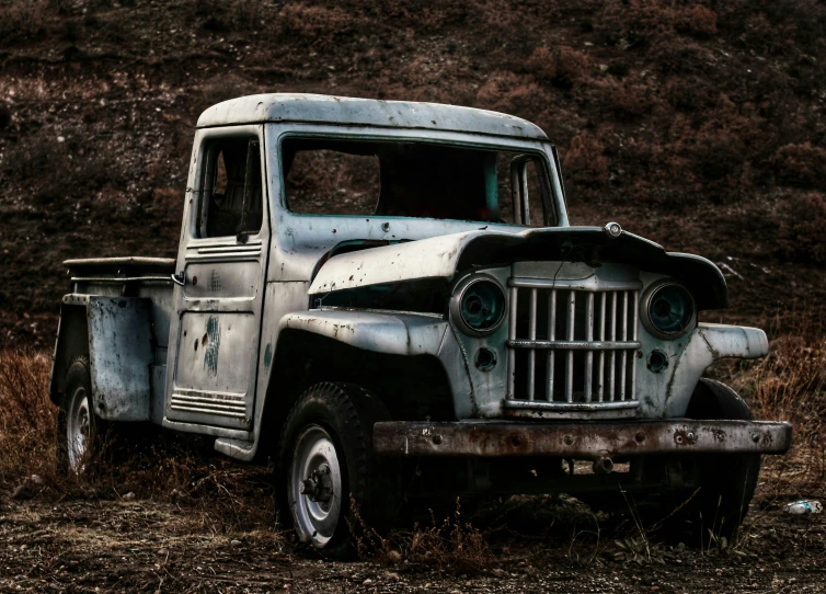an old pick up truck is parked on some weeds