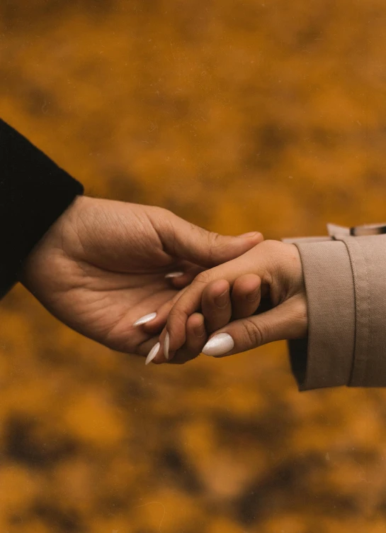 the hands of two people with white nails on their fingers