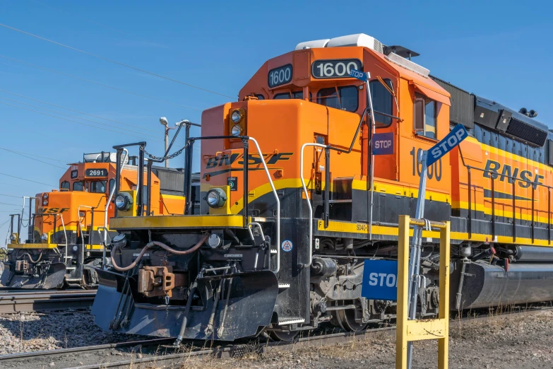 two orange trains are sitting next to each other on the tracks