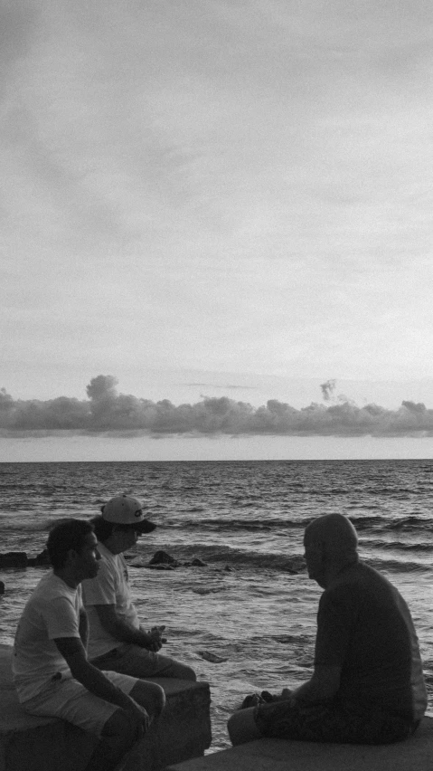 a group of people sitting at the beach