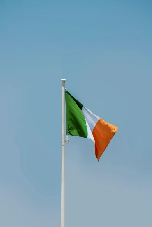 the irish and white flag is flying on a flag pole