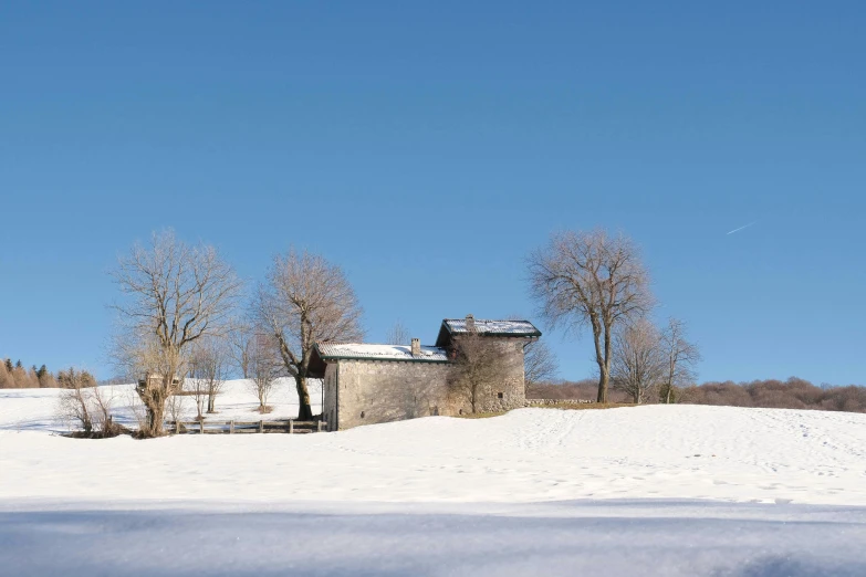 an old building stands on the snow - covered landscape