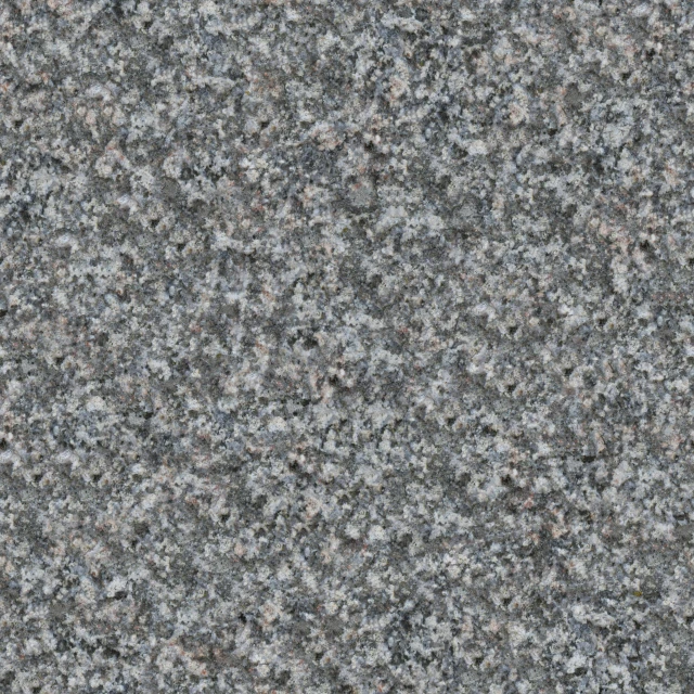 a very large gray stone wall with dark grey spots