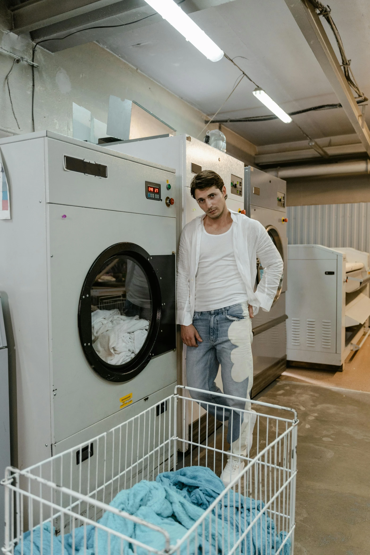 a man standing next to an ironing board in a laundry room