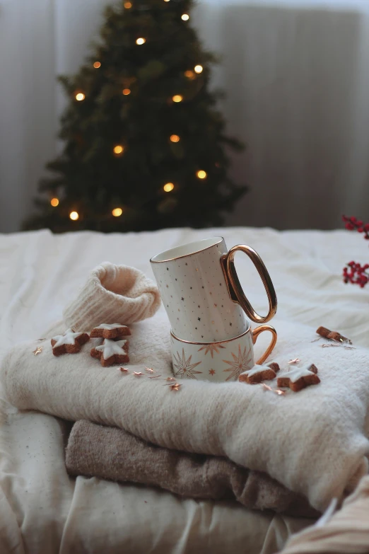 a bed has a blanket, socks and christmas trees