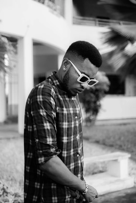 a man wearing sunglasses stands by some water