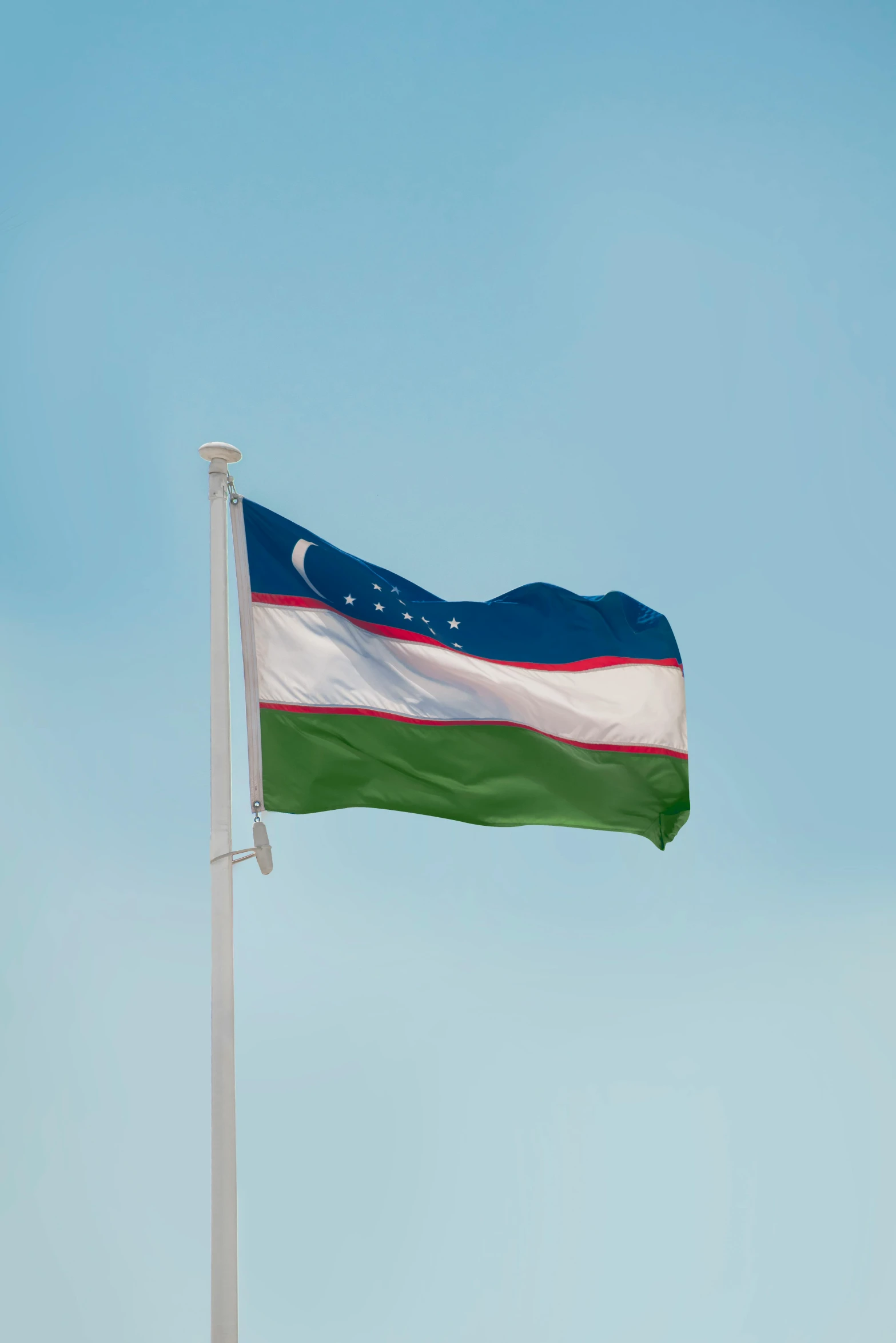 the flag of uzbekistan is shown waving in the wind