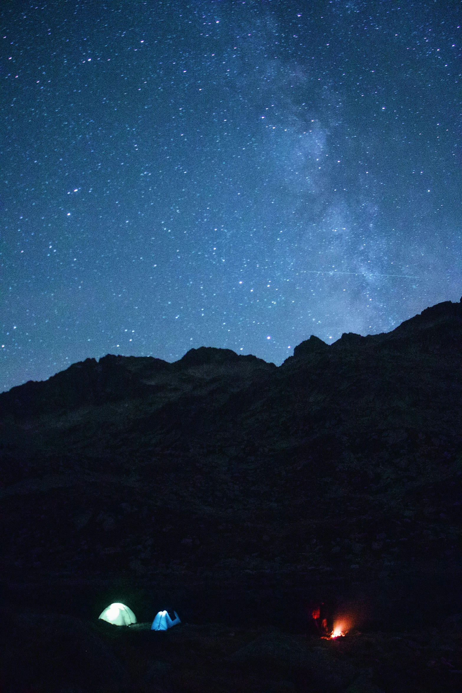 three tents sit in the night time setting