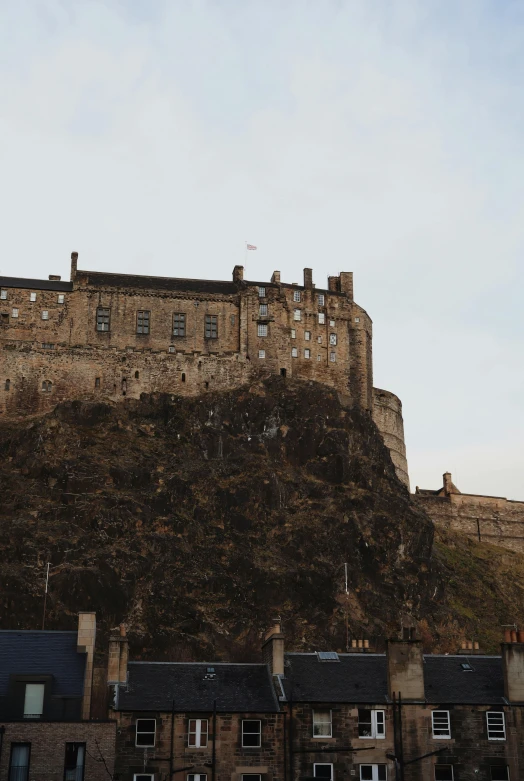 castle with tall roof sitting on the top of a hill