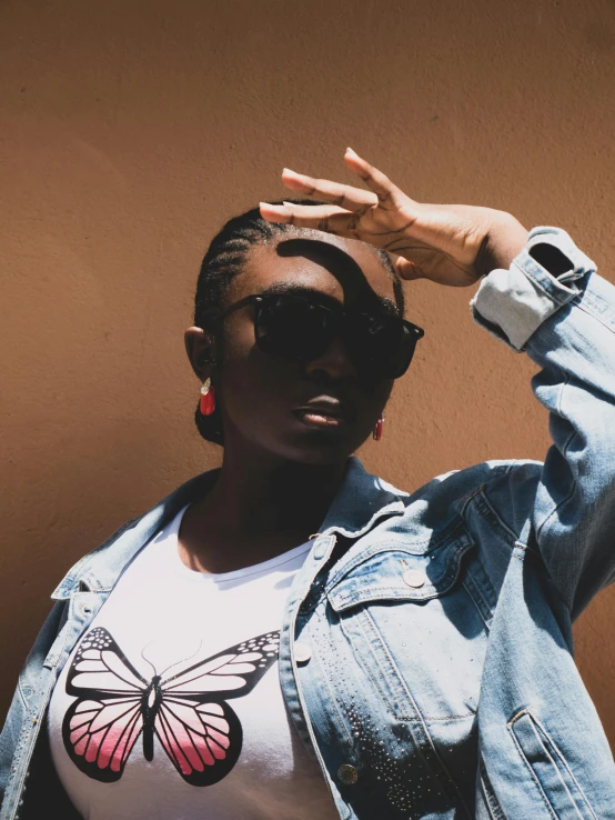 a woman in denim jacket with a erfly on her t shirt