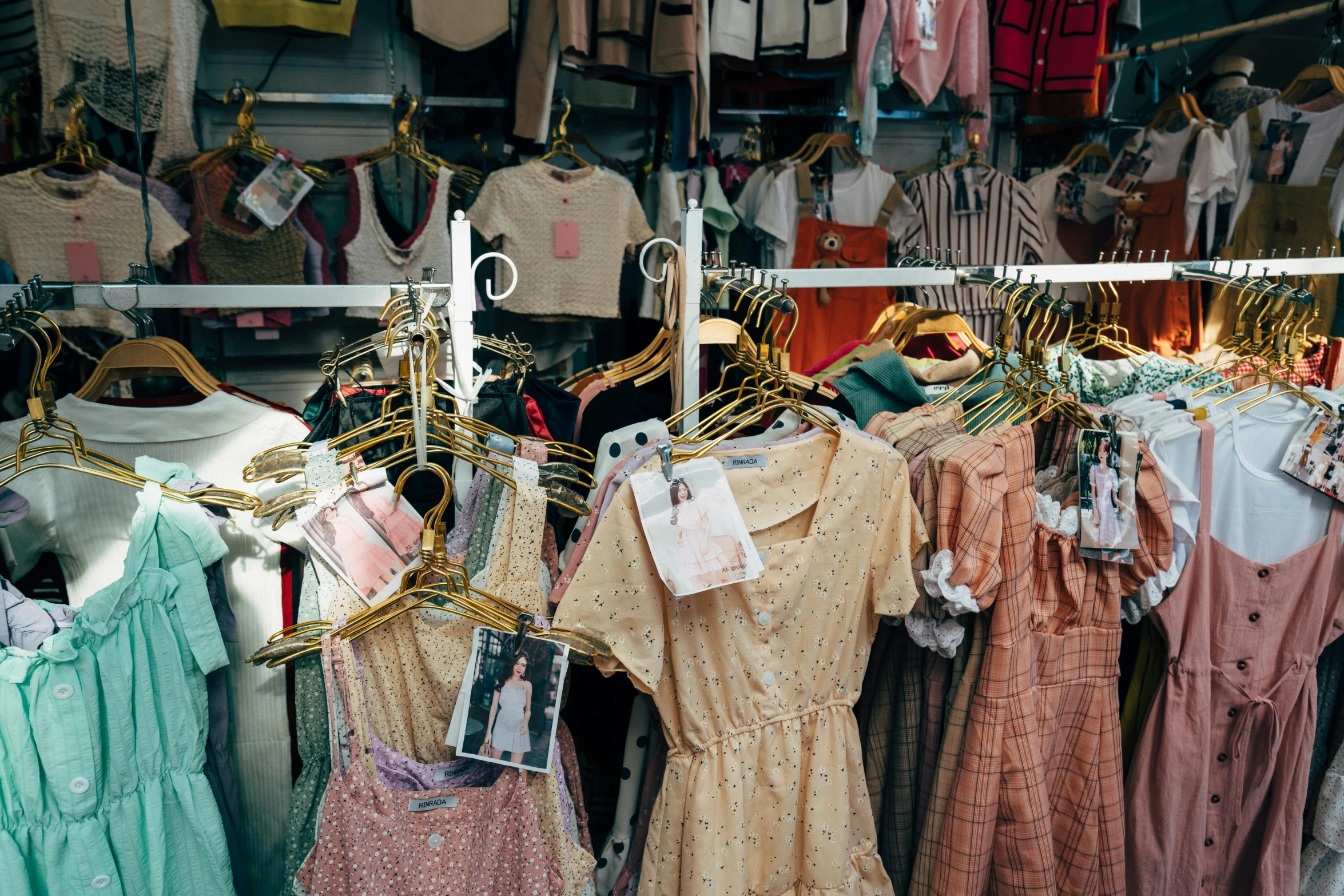 a clothing stand filled with children's and baby's dress