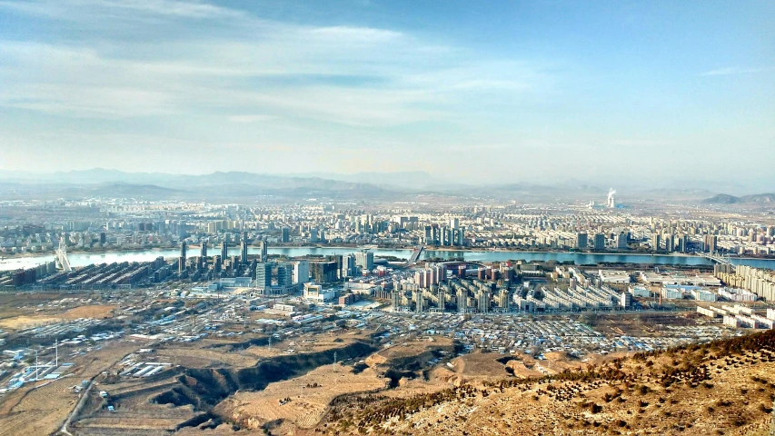 a picture of an elevated city skyline with a lake in front