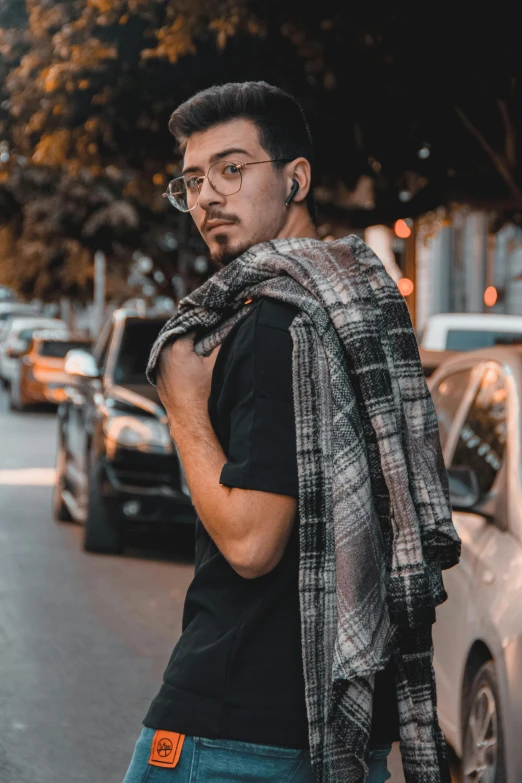 a man is standing on the street while looking off to his left