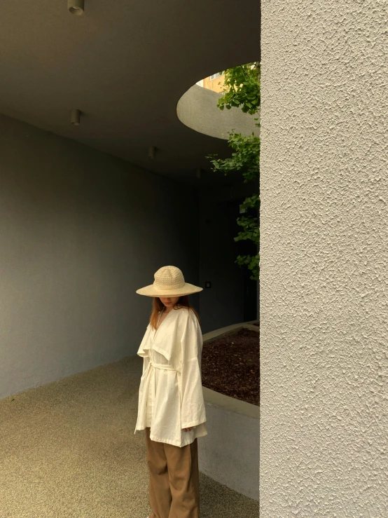 a woman with a hat standing in an open doorway