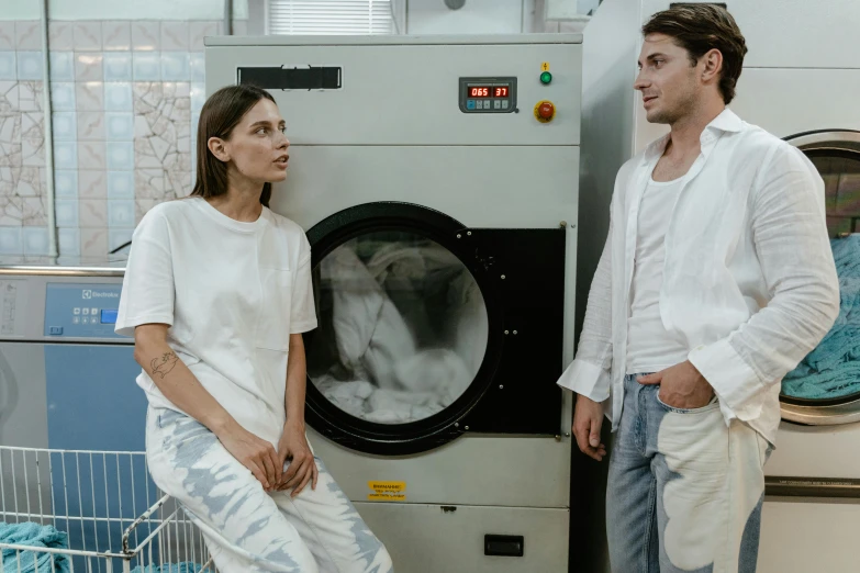 two people standing near a washer in the factory