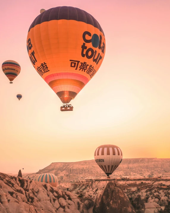  air balloons with the sun setting on a hill side