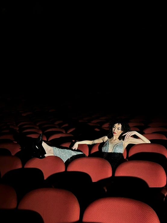 an artistic pograph of a woman in the middle of rows of seats