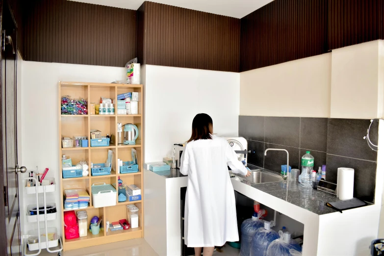 a person standing in a kitchen with cabinets