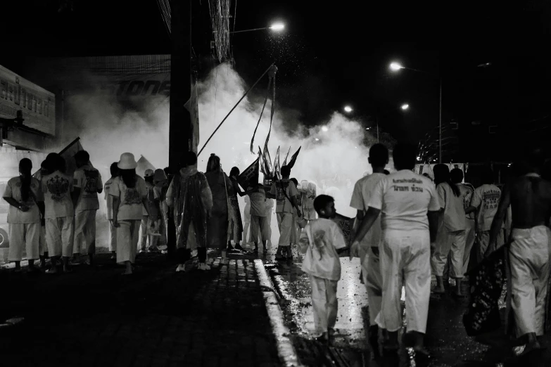 a crowd is lined up against a wall with smoke rising