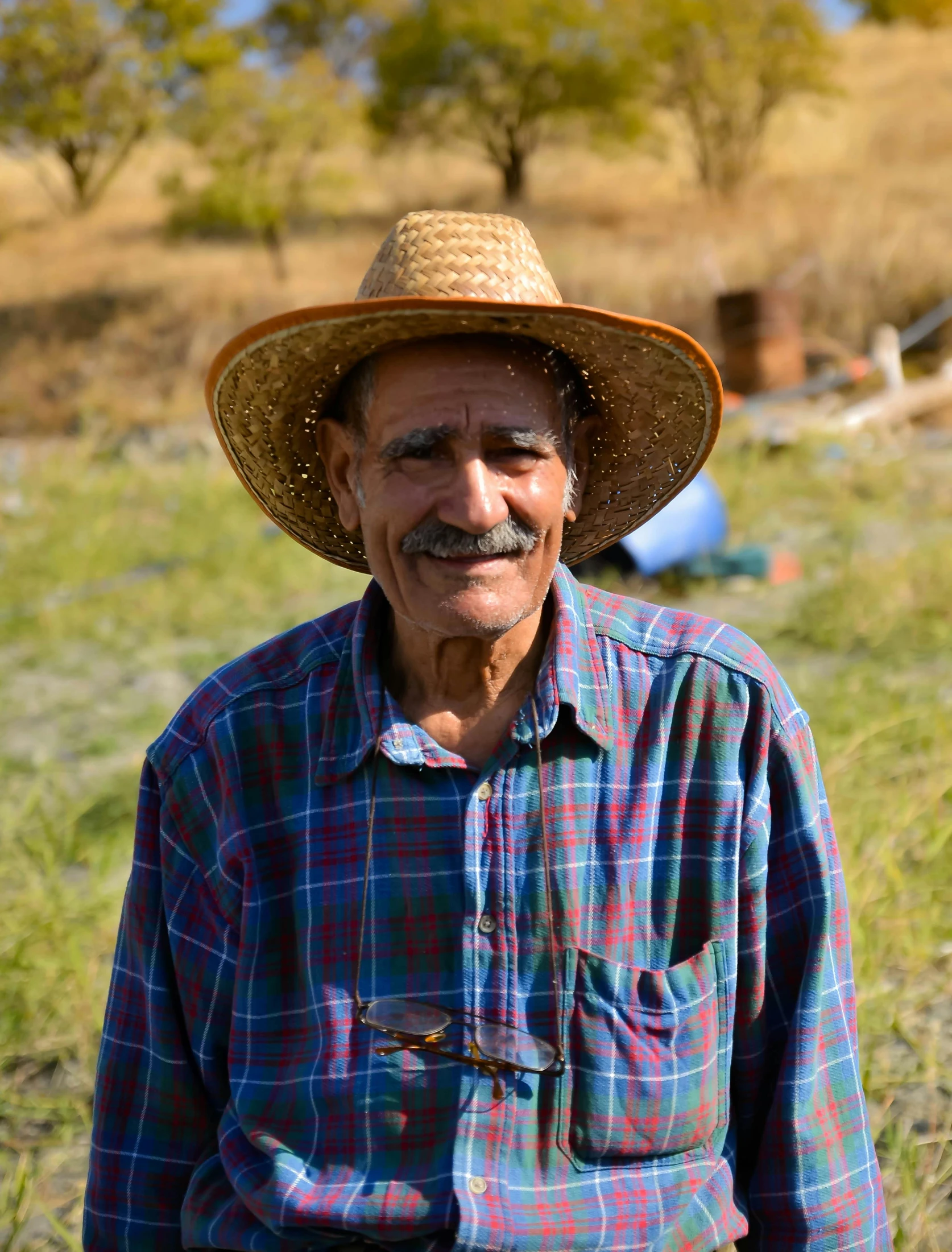 a man with a straw hat standing in a field