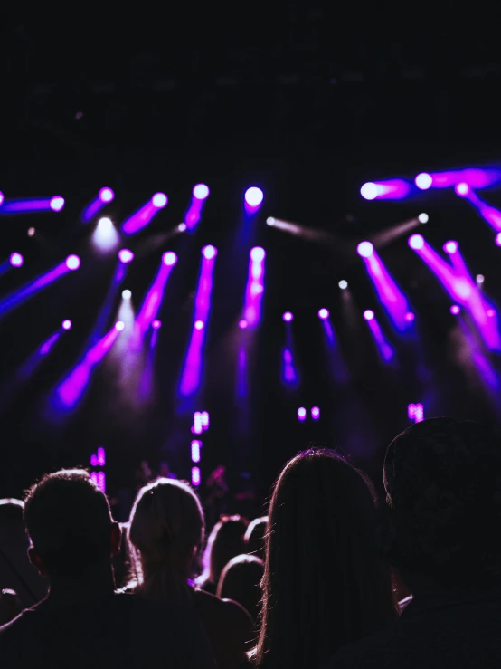 purple and blue lights shining on a large stage