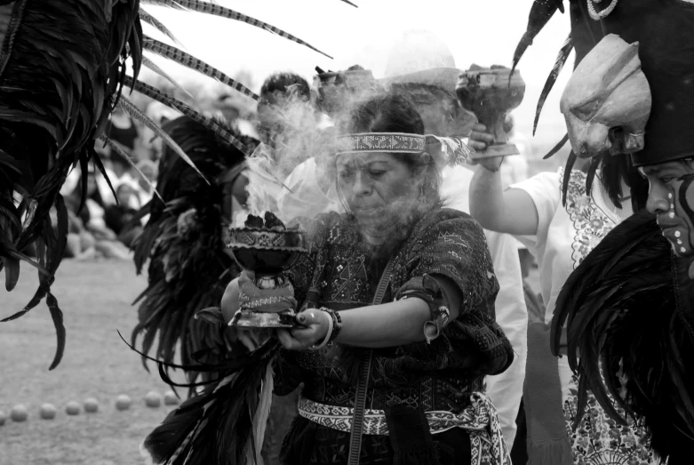 two women dressed in native american costumes holding torches