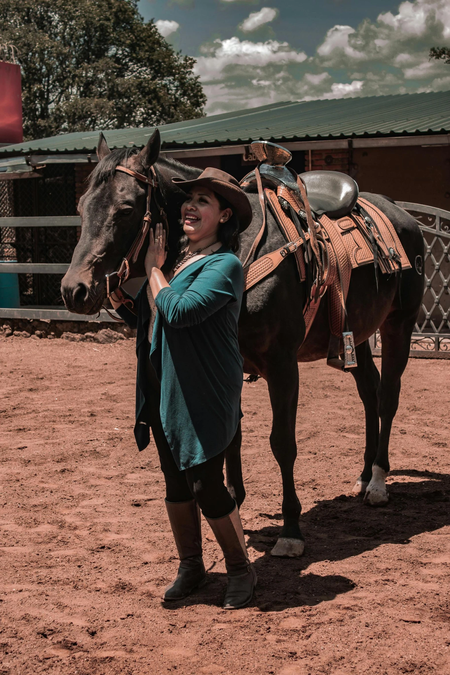 a woman in cowboy hats is standing by a horse