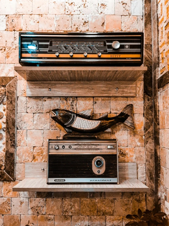 an old, dirty stereo set is hanging on the brick wall