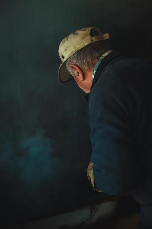 man with a baseball cap and jacket looking over his shoulder