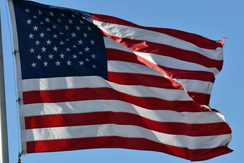 an american flag in front of a blue sky