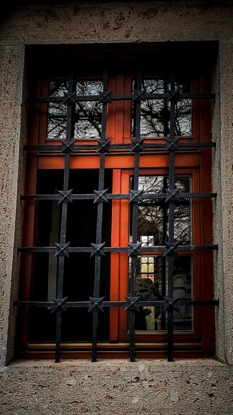 a window with bars over it and the blinds closed