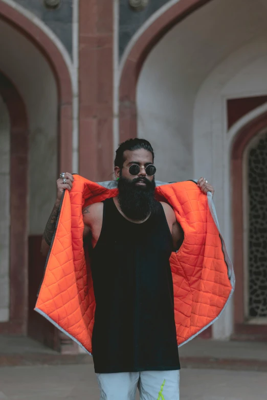 a man holding onto a bright orange vest