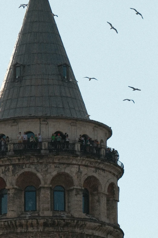 many people standing on top of the roof of a tower