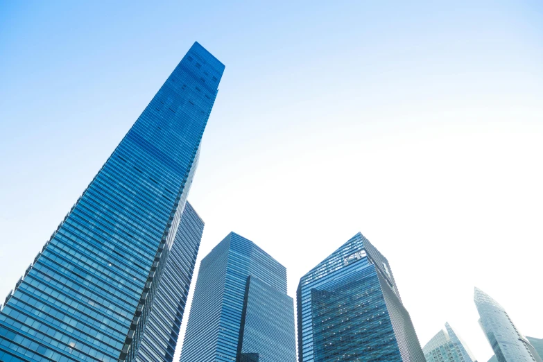 a group of three tall buildings with blue glass towers