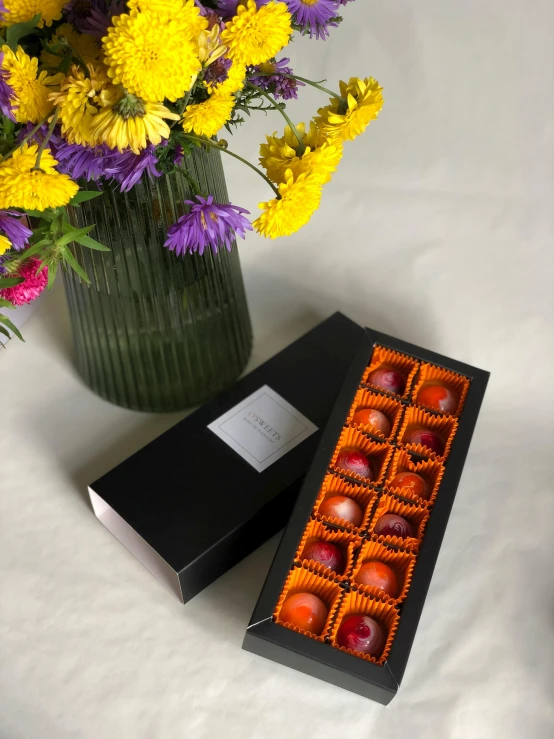 two small boxes of chocolates in front of flowers