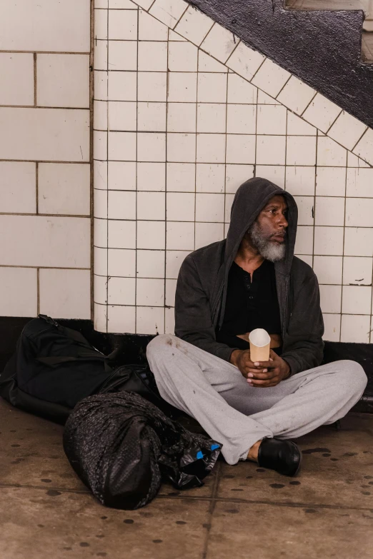 a man with a backpack and coffee cup on a sidewalk