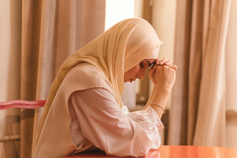 a woman sitting at a table in a room talking on her cell phone