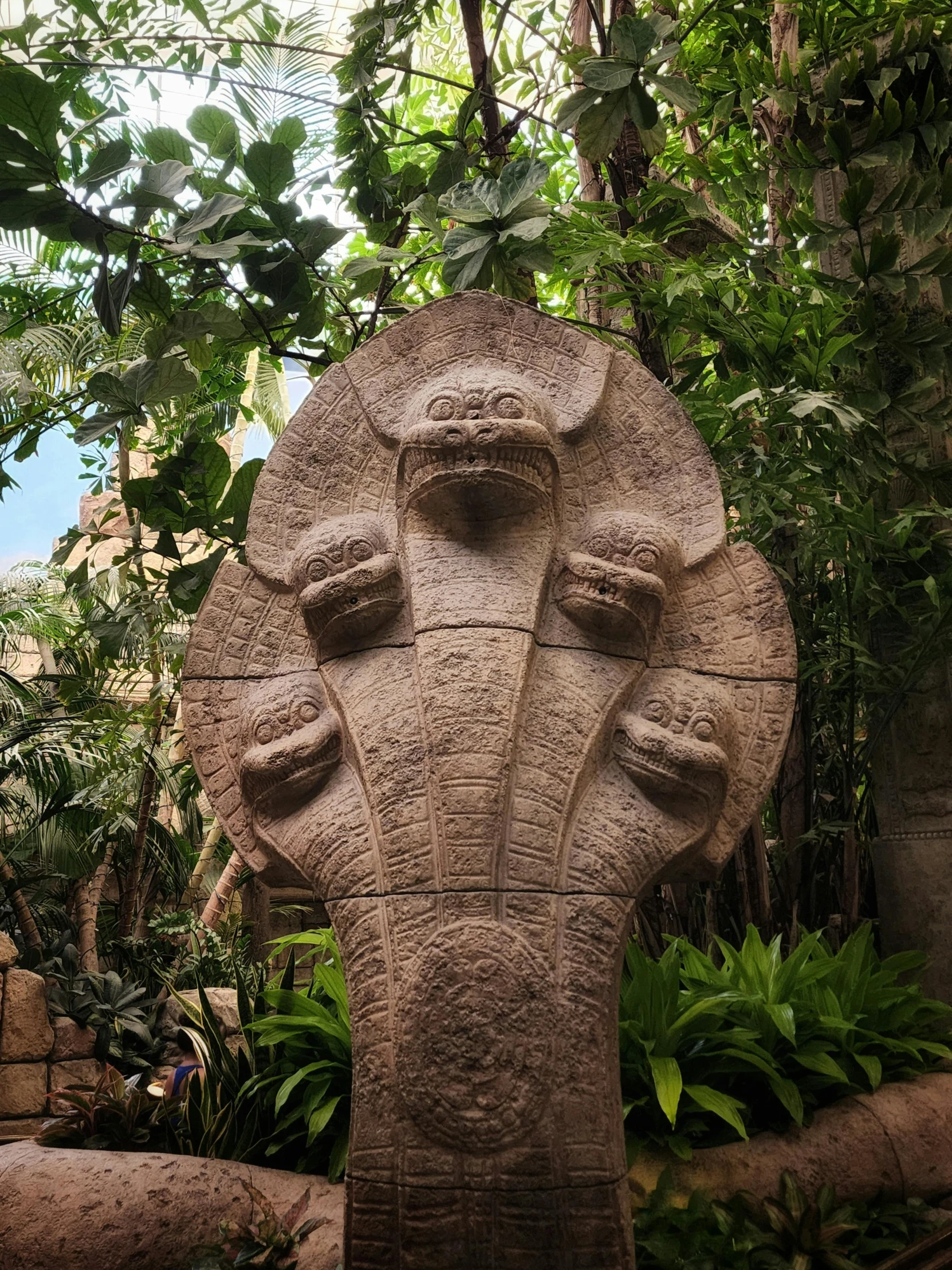this stone sculpture is in the center of a garden