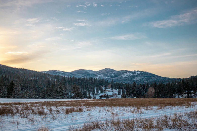 mountains with snow on the ground and clouds in the sky